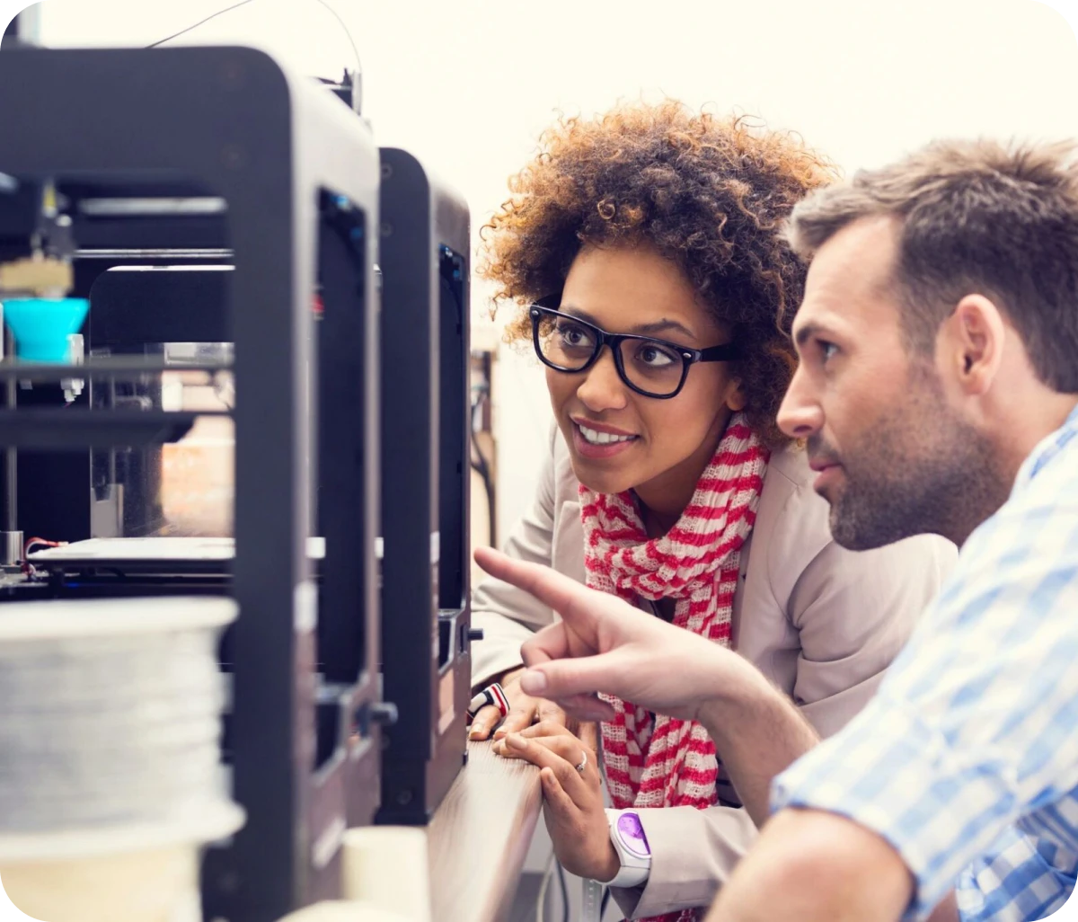 Two individuals examining 3D printing process